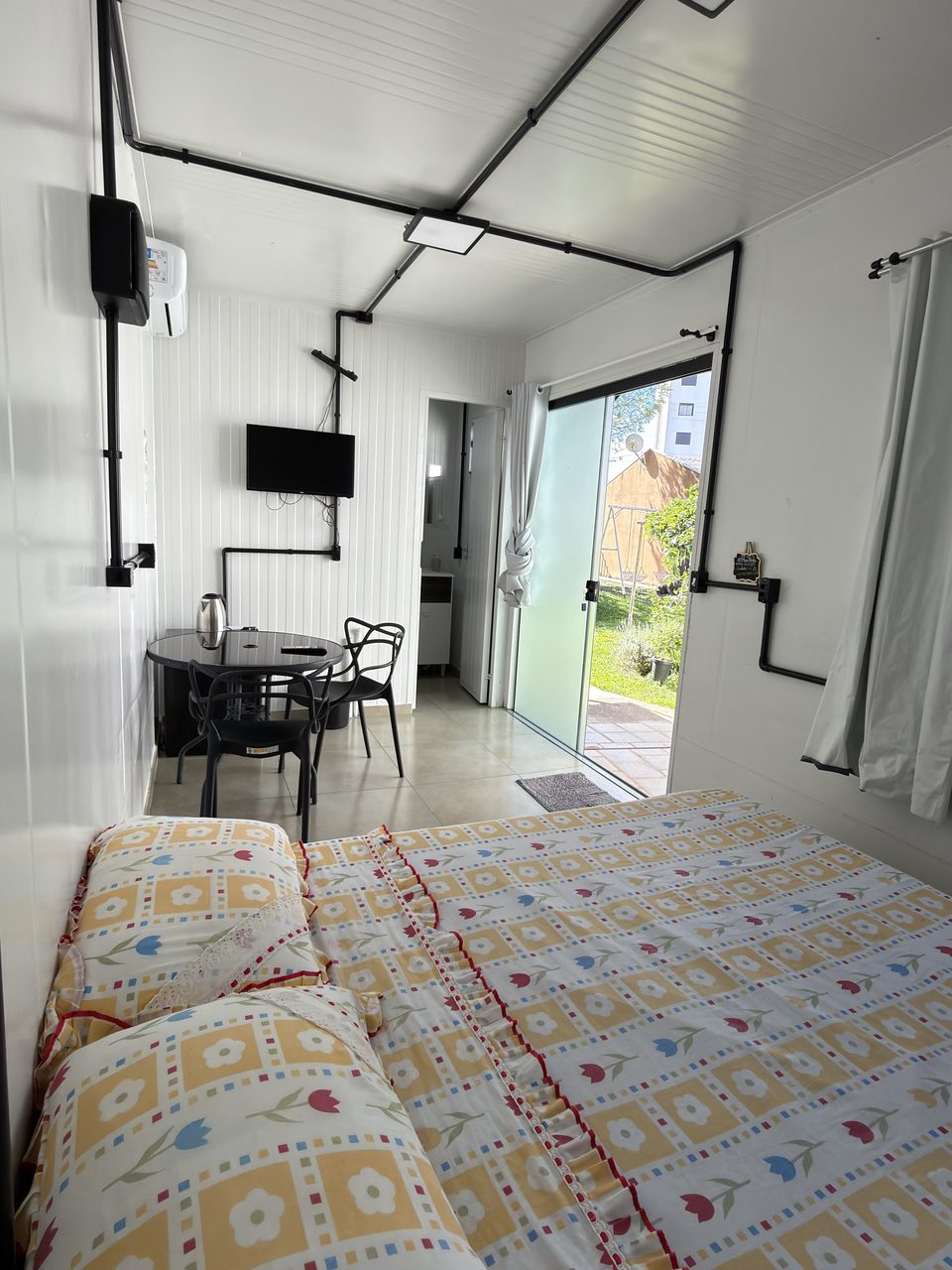 A porta de vidro do Quarto 5, aberta para o jardim.