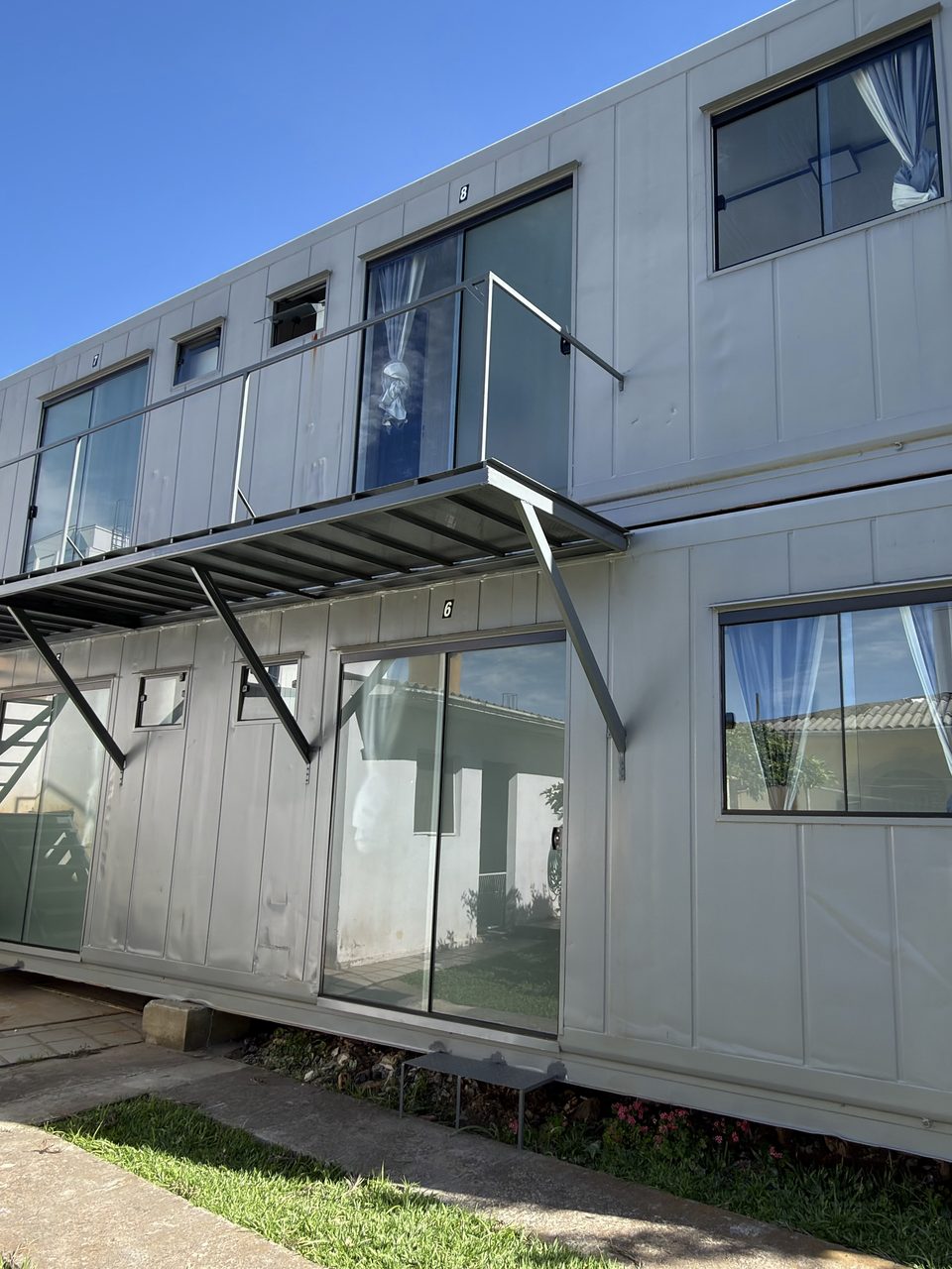 Os containers por fora: dois andares, com escada e sacada.