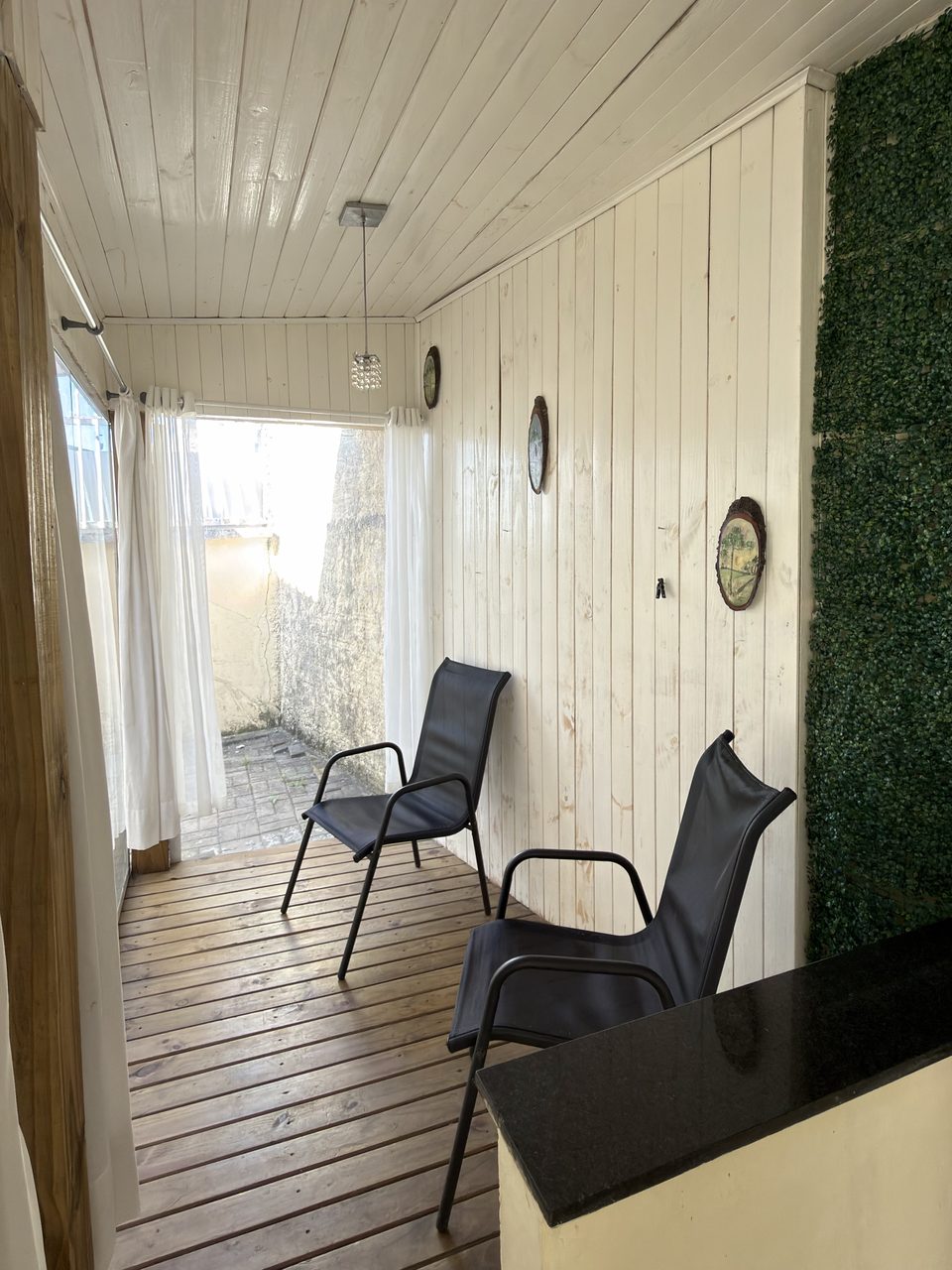 O deck da varanda do Quarto 2, com duas cadeiras.