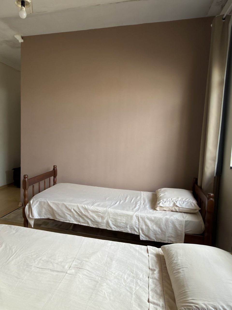 As camas do Quarto 3 e a TV na parede.