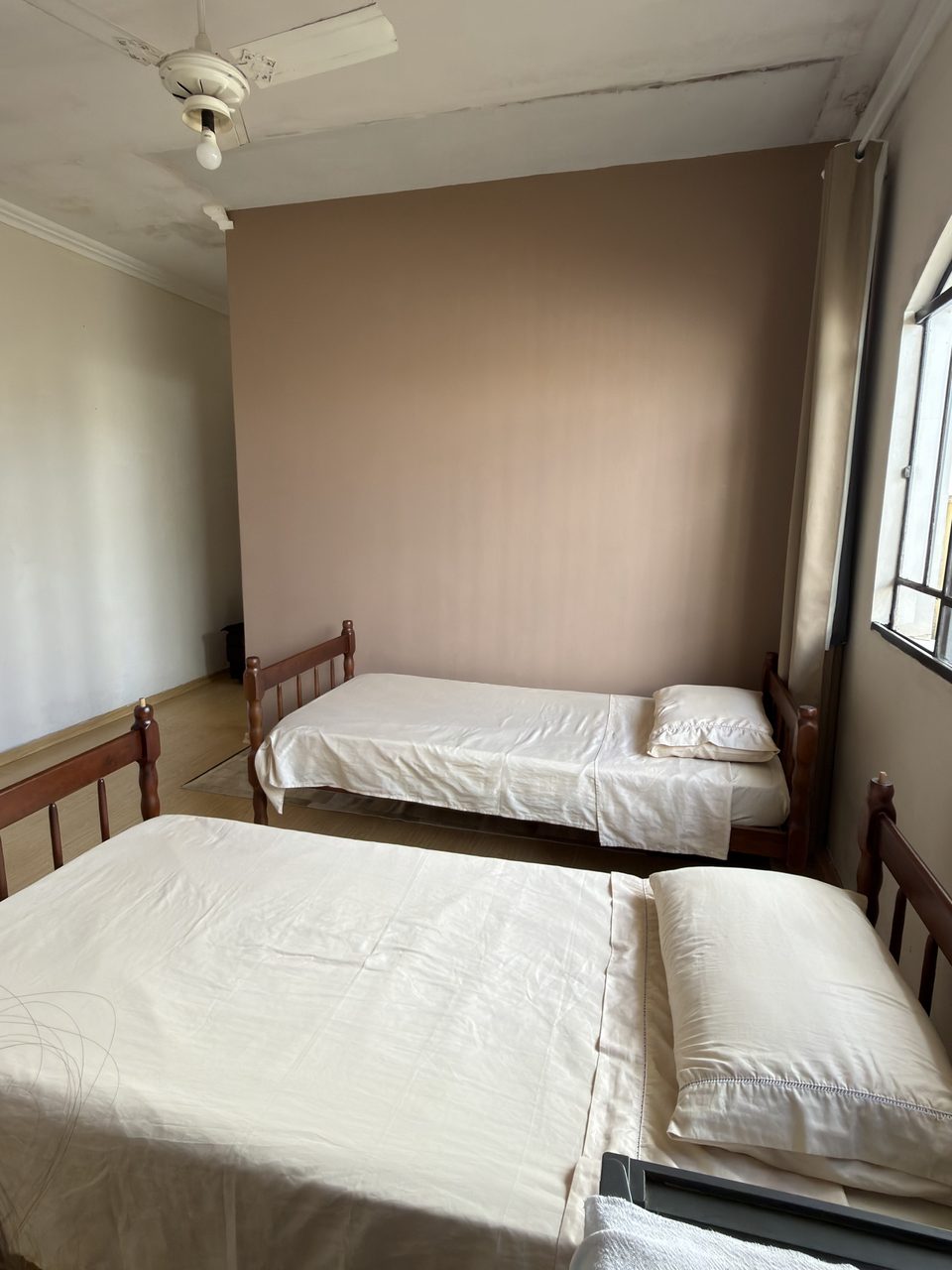 O Quarto 3 com o ventilador de teto e a janela.