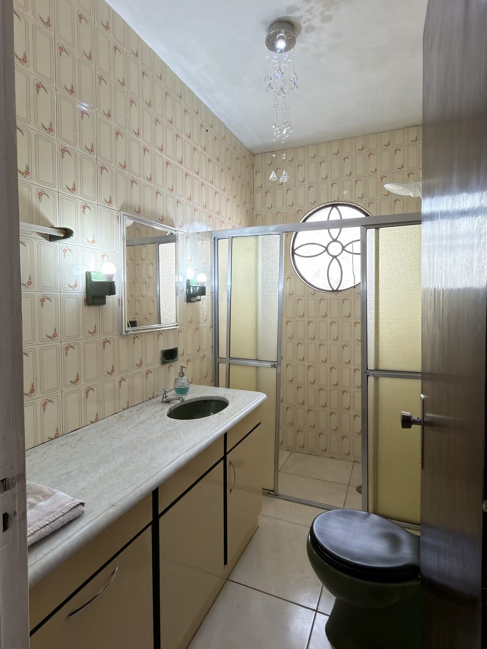 O banheiro do Quarto 4, com bancada, box e louça verde.
